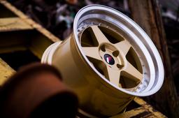 JR Wheels JR6 Gold alloy wheel mounted on car in an atmospheric setting