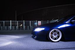 JR Wheels JR7 Silver alloy wheel mounted on car in an atmospheric setting