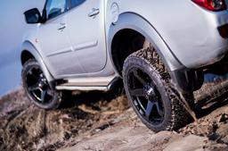 JR Wheels JRX5 Black alloy wheel mounted on car in an atmospheric setting