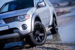 JR Wheels JRX5 Black alloy wheel mounted on car in an atmospheric setting