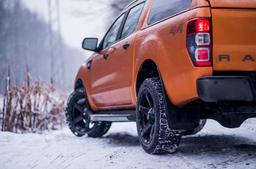 JR Wheels JRX5 Black alloy wheel mounted on car in an atmospheric setting