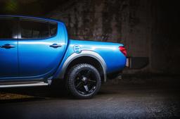 JR Wheels JRX5 Black alloy wheel mounted on car in an atmospheric setting