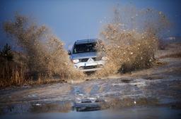 JR Wheels JRX5 Black alloy wheel mounted on car in an atmospheric setting