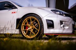 JR Wheels SL-01 Guld aluminiumfälg monterade på bil i stämnigsfull miljö