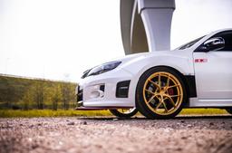 JR Wheels SL-01 Guld aluminiumsfælge monteret på bil i en stemningsfuld omgivelse