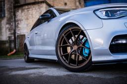 JR Wheels SL-01 Bronze alloy wheel mounted on car in an atmospheric setting