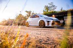 JR Wheels SL-02 Guld aluminiumfälg monterade på bil i stämnigsfull miljö