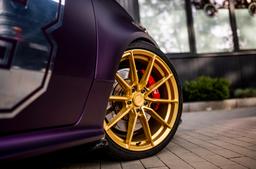 JR Wheels SL-02 Guld aluminiumfälg monterade på bil i stämnigsfull miljö