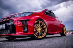 JR Wheels SL-02 Guld aluminiumfälg monterade på bil i stämnigsfull miljö