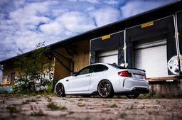 JR Wheels SL-02 Brons aluminiumfälg monterade på bil i stämnigsfull miljö