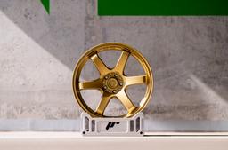 JR Wheels SL-03 Gold alloy wheel mounted on car in an atmospheric setting