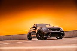 JR Wheels SL-03 Black alloy wheel mounted on car in an atmospheric setting