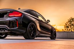 JR Wheels SL-03 Black alloy wheel mounted on car in an atmospheric setting