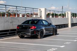 JR Wheels SL-04 Musta alumiinivanteet asennettuna autoon tunnelmallisessa ympäristössä