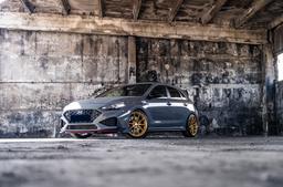 JR Wheels SL-04 Guld aluminiumfälg monterade på bil i stämnigsfull miljö