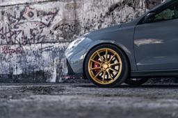 JR Wheels SL-04 Guld aluminiumfälg monterade på bil i stämnigsfull miljö