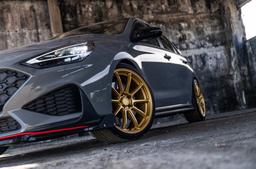 JR Wheels SL-04 Guld aluminiumfälg monterade på bil i stämnigsfull miljö