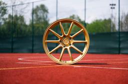 JR Wheels SL-04 Guld aluminiumfälg monterade på bil i stämnigsfull miljö