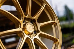 JR Wheels SL-04 Guld aluminiumfälg monterade på bil i stämnigsfull miljö