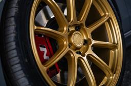 JR Wheels SL-04 Guld aluminiumfälg monterade på bil i stämnigsfull miljö