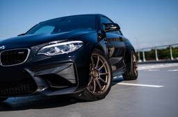 JR Wheels SL-04 Brons aluminiumfälg monterade på bil i stämnigsfull miljö